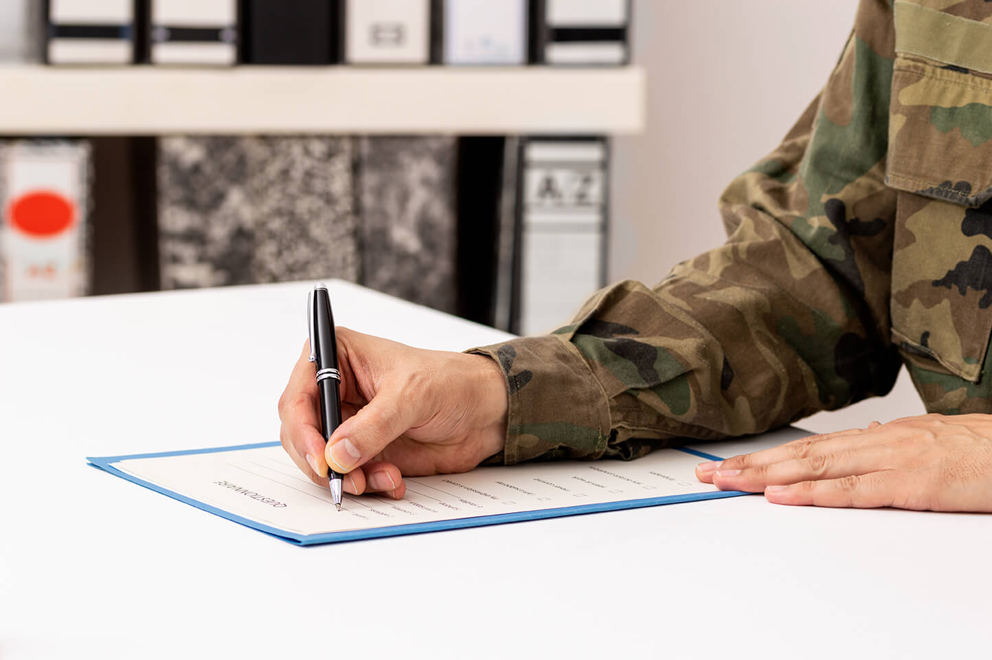 man in military uniform signing papers