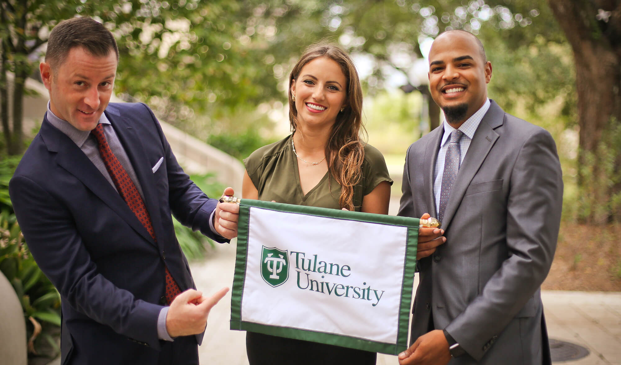 group of 3 people with tulane flag