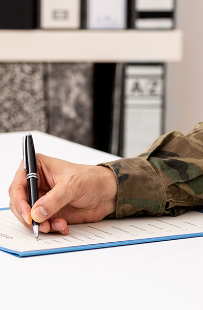 Closeup of military veteran's hand filling out paperwork - Tulane SoPA