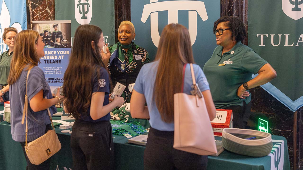 College fair booth with students interacting with representatives.