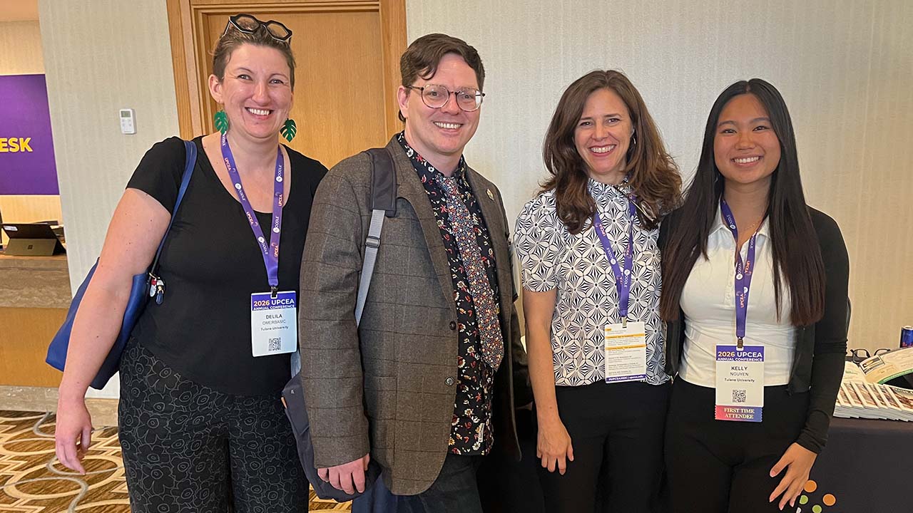Four people posing for a photo at a conference.