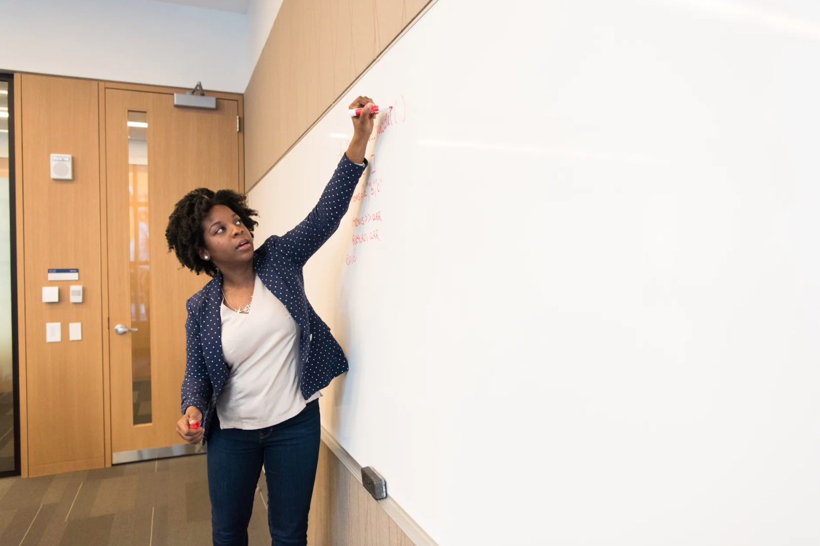 A teacher writing on a whiteboard