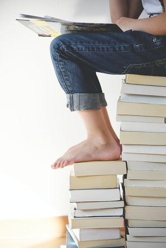 A person sitting an a stack of books