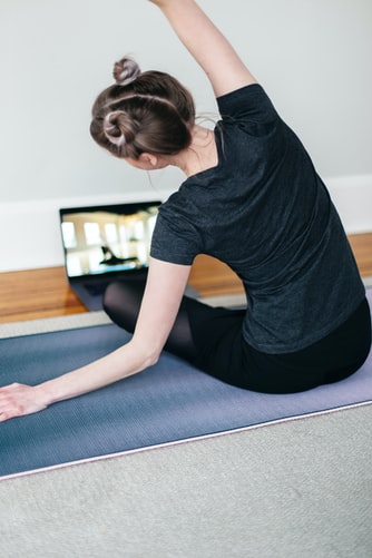 A person doing yoga while watching an instructional video