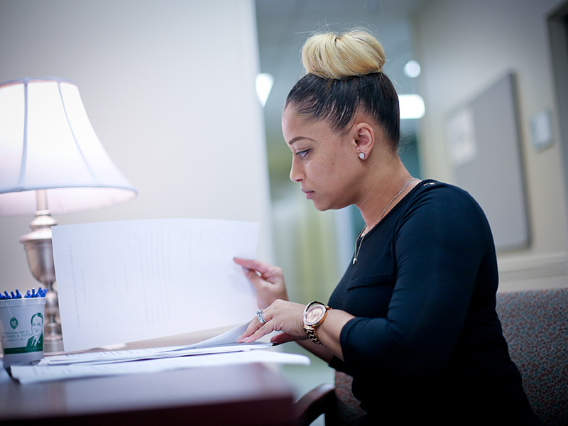 A woman at a desk going over paperwork