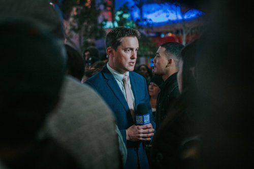 TV reporter speaking into microphone on camera - Tulane School of Professional Advancement