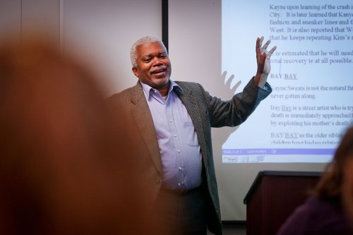 Tulane SoPA program faculty member teaching in front of a projector screen
