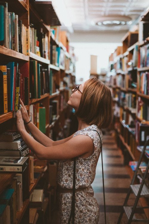 A woman in a library representing master's degree programs at Tulane School of Professional Advancement in New Orleans, LA