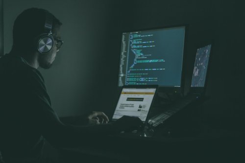Technology professional wearing headphones at a computer - Tulane SoPA