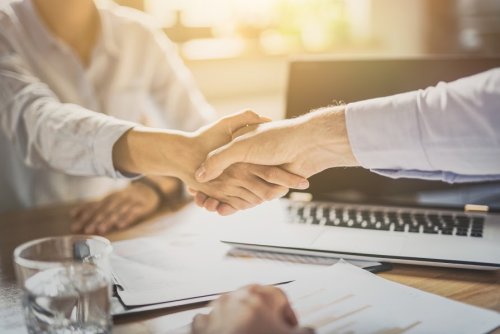 Improve your organizational leadership skills Two business people shaking hands over a desk