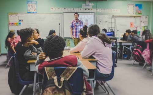Students in a classroom looking at the teacher - Tulane School of Professional Advancement