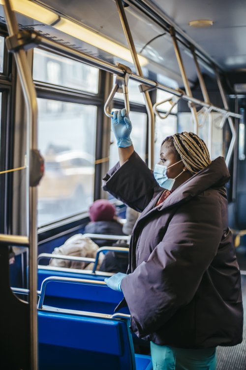 Learn about public policies and community health A woman wearing a mask and gloves on a bus