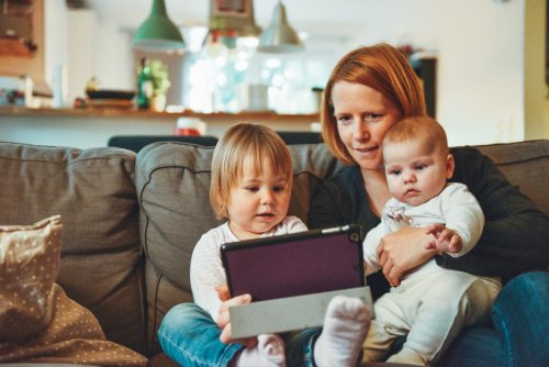 Tips to pursuing a degree as a parent A mom looking at a tablet with her two children