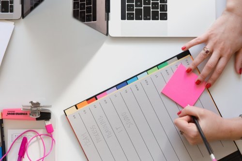How to handle the transfer student process A person writing on a sticky note in their planner