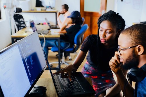 Learn more about becoming an IT consultant People looking at code together on a computer
