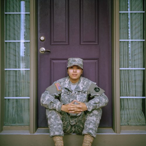 Hire a veteran A woman in army cammies sitting in front of a door