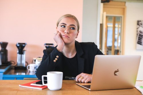 A woman thinking in front of her computer