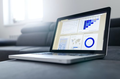 Laptop on a couch displaying charts and graphs - Tulane School of Professional Advancement