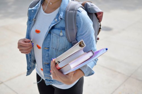 Transfer studen on university campus carrying books - Tulane School of Professional Advancement