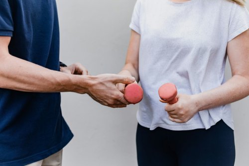 A trainer and a client holding dumbells