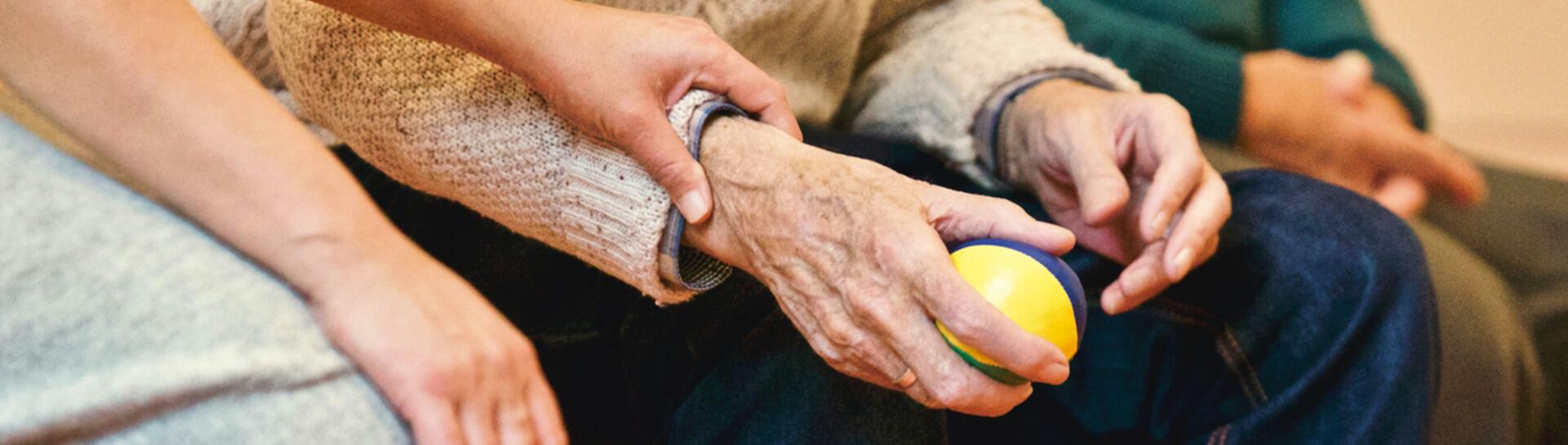 A person holding an elderly person's arm