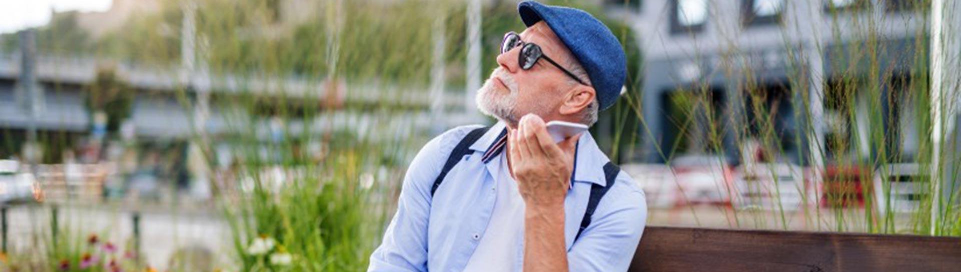 A vision impaired man uses a smartphone.