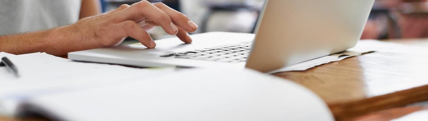 A person on a laptop representing test-taking tips for online learners by Tulane School of Professional Advancement in New Orleans, LA