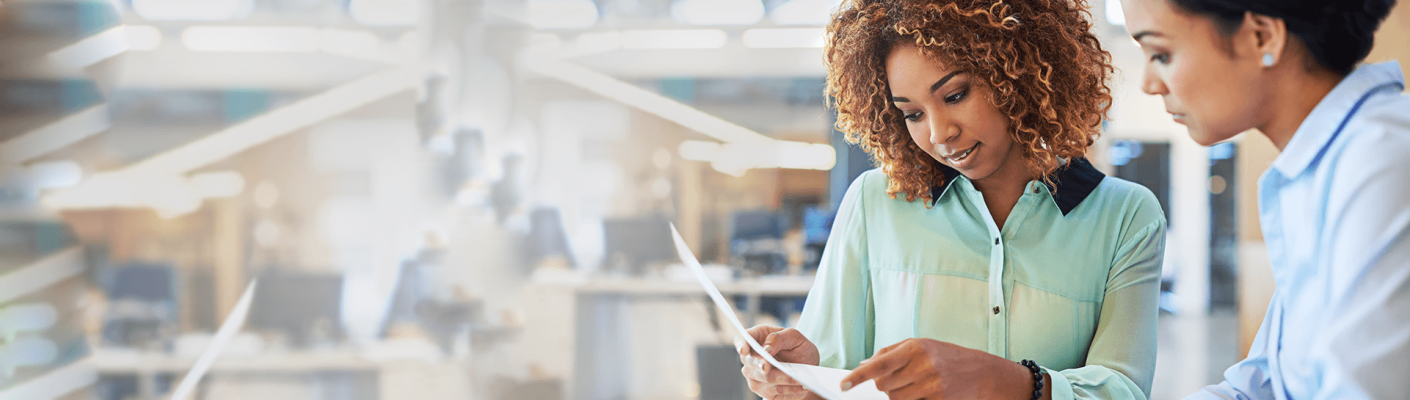 Two business women looking at a document together