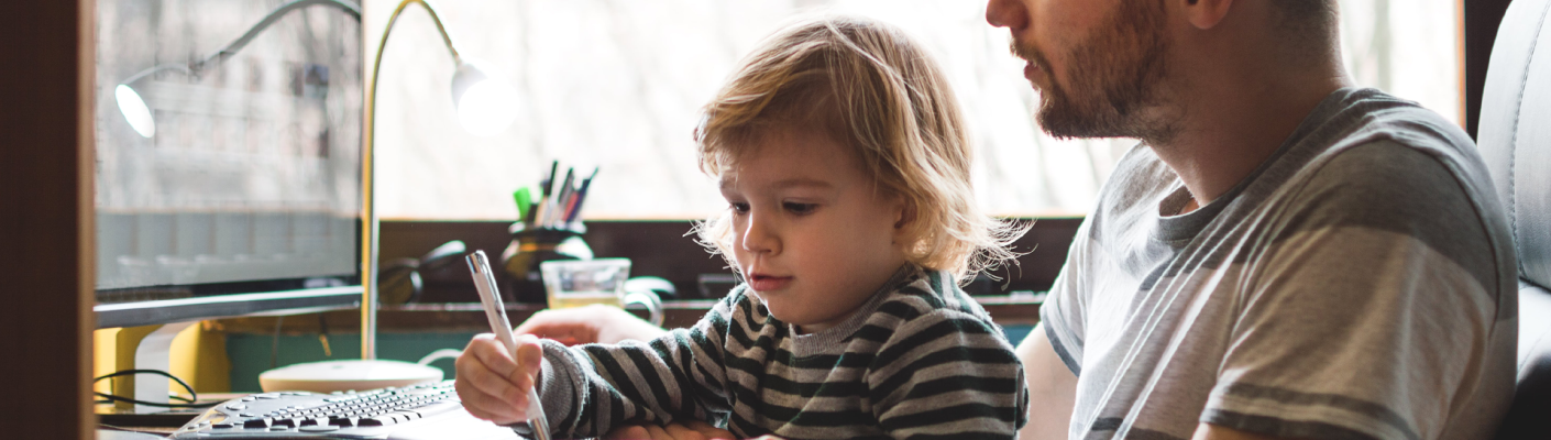 A parent holding a child on their lap while using the computer
