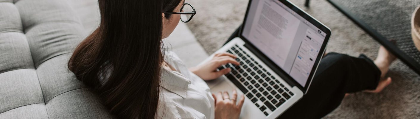 A student writing a paper on a laptop
