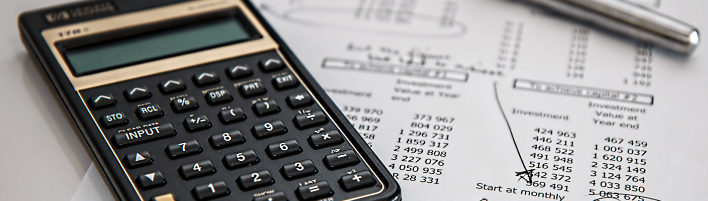 A calculator, pen, and sheet of paper with numbers on it