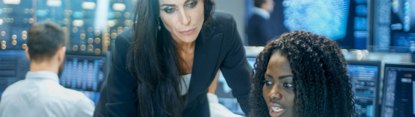 Female IT engineers consult on cybersecurity 101 basics at a computer.