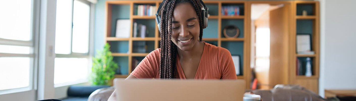 A person looking at a laptop and smiling