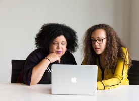 Two women looking at a laptop screen - Tulane School of Professional Advancement