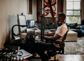 A professional working from home using tech equipment
