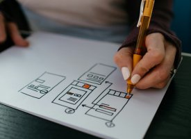 A person drawing a UI wireframe