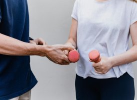A trainer and a client holding dumbells