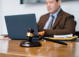 A gavel sitting on a desk of a person working