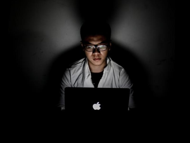 A person using a laptop in the dark