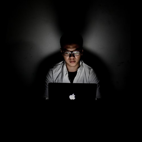 A person using a laptop in the dark